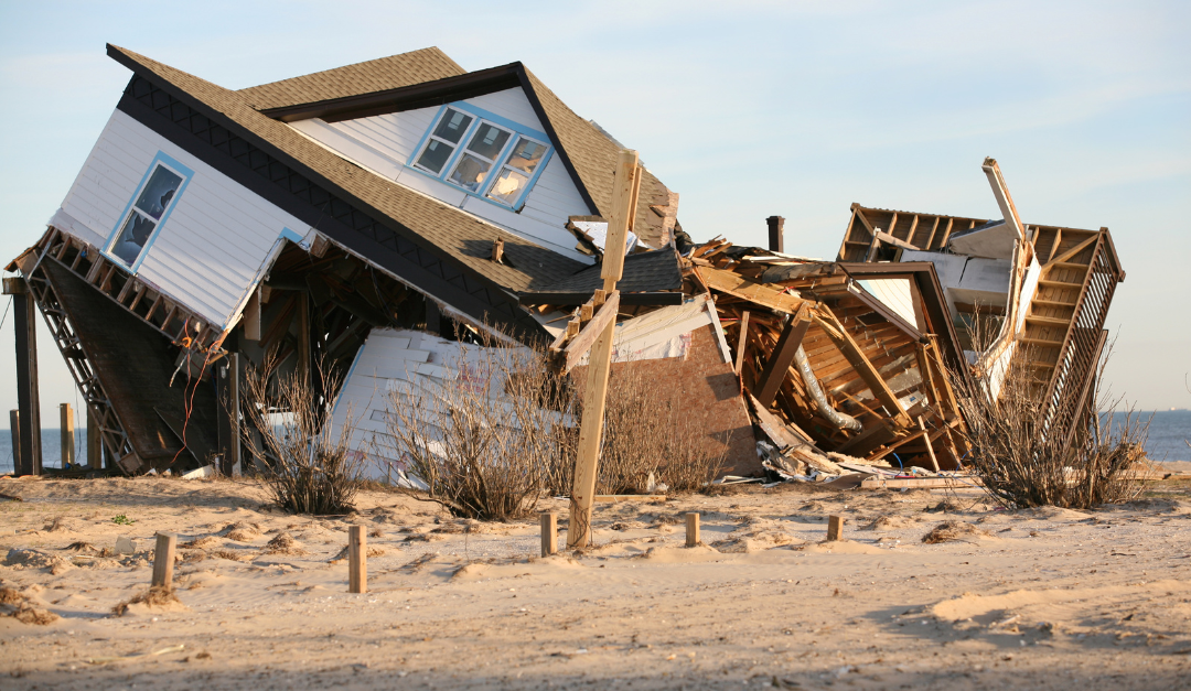 A house partially destroyed, leaning at a steep angle.